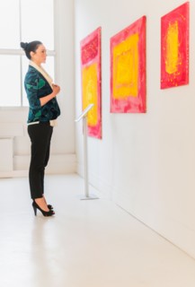 Woman looking at paintings in museum.