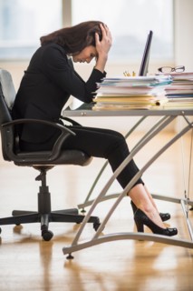 Businesswoman with head in hands.