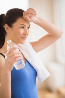 Woman drinking water in gym.