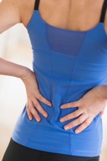 Midsection of woman with hands on back.