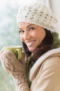 Portrait of woman in warm clothes holding mug.