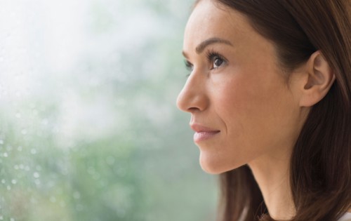 Woman next to rainy window.