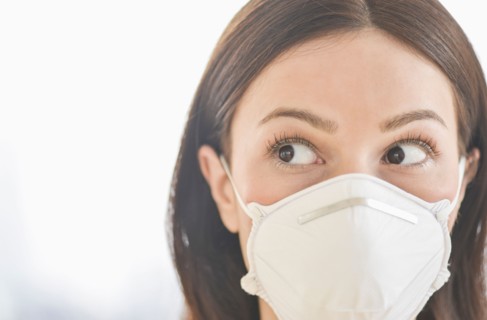 Studio portrait of woman wearing flu mask.