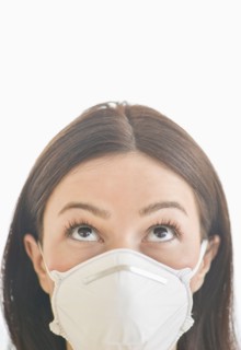 Studio portrait of woman wearing flu mask.