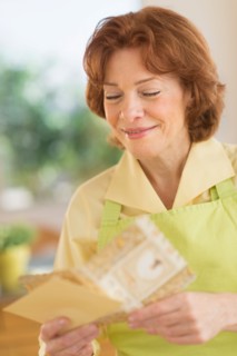 Senior woman reading greeting card.