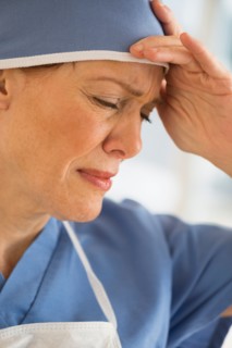 Female surgeon suffering headache.