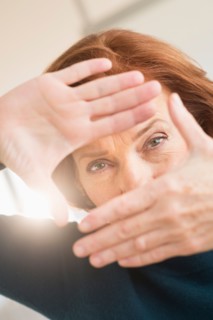 Hands framing face of businesswoman.
