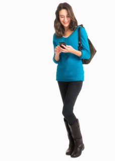 Studio shot of young woman text messaging.