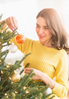 Woman decorating christmas tree.
