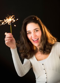 Woman holding sparkler.