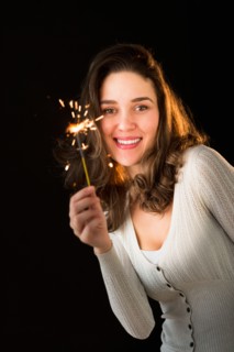 Woman holding sparkler.