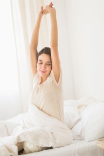 Woman stretching on bed.