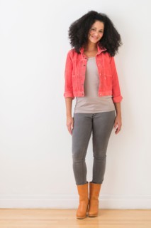 Portrait of smiling mid adult woman standing against wall.