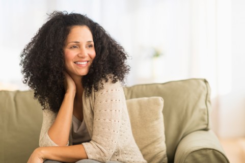 Portrait of mid adult woman sitting on sofa.