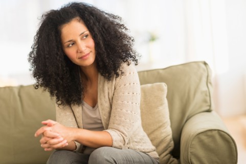 Portrait of mid adult woman sitting on sofa.