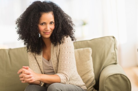 Portrait of mid adult woman sitting on sofa.