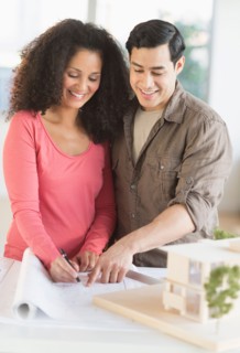 Smiling couple with model home.
