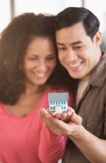 Smiling couple with model home.