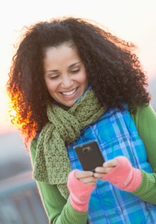 Portrait of mid adult woman using mobile phone at sunset.