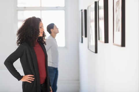 Visitors looking at artworks in gallery.