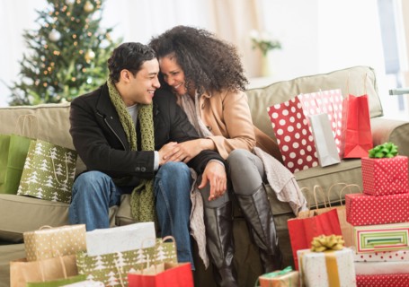 Couple with Christmas presents in living room.