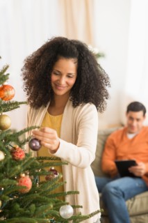 Woman decorating Christmas tree.