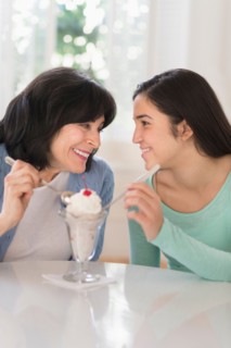 Grandmother and granddaughter (16-17) sharing ice-cream.