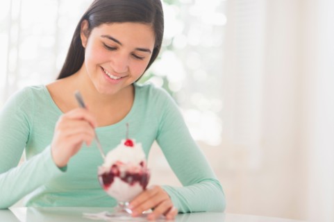 Teenage girl (16-17) eating ice-cream.