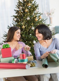 Grandmother and granddaughter (16-17) wrapping christmas gifts.