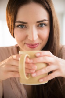 Portrait of young woman holding coffee cup