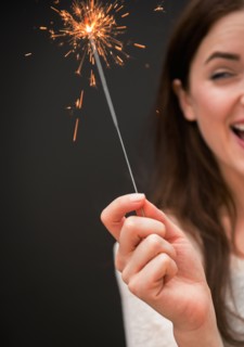 Young woman holding firework