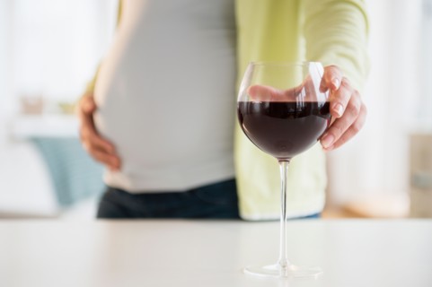 Pregnant woman with glass of red wine