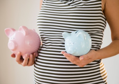 Pregnant woman holding piggy banks