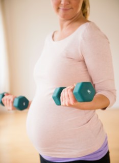 Pregnant woman exercising with dumbbell