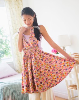 Front view of teenage girl ( 16-17 years) trying on dress