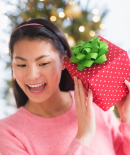 Front view of teenage girl ( 16-17 years) holding Christmas gift