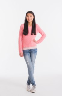 Portrait of teenage girl ( 16-17 years) wearing jeans and pink sweater