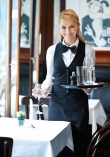 Portrait of young waitress holding tray and wine glasses