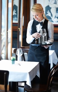 Portrait of young waitress setting table