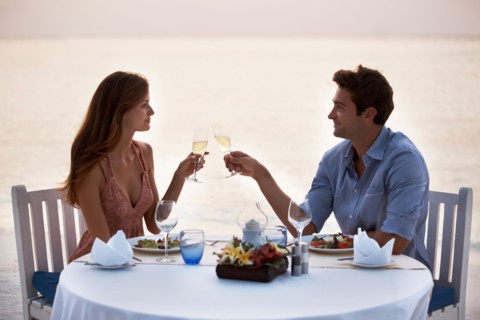 Couple eating at table on tropical beach