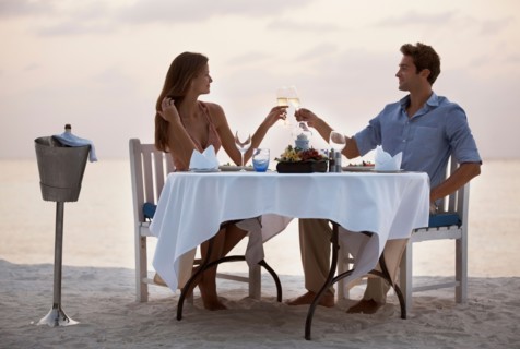 Couple eating at table on tropical beach
