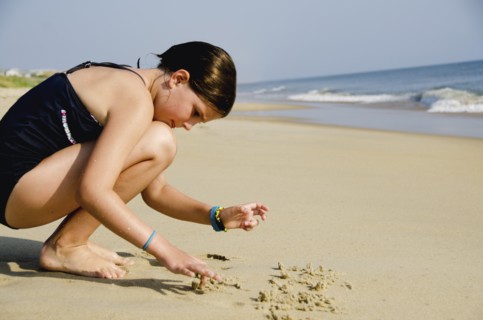 Girl (8-9) playing at beach