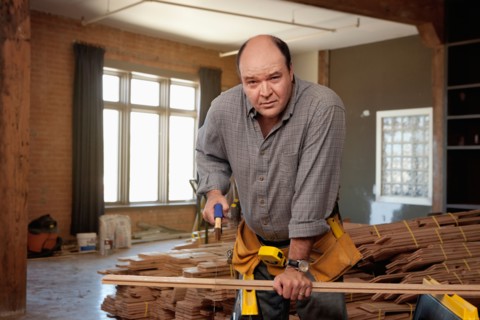 Man cutting piece of plank