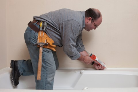 Man with Caulk Gun working in bathroom