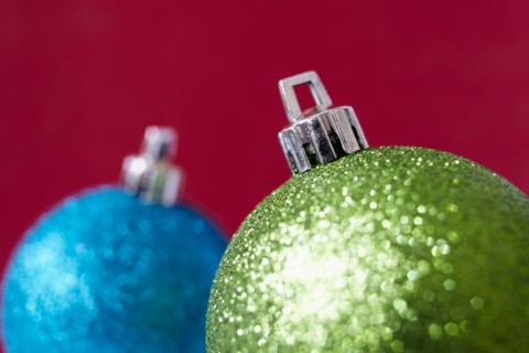 Close up of shiny Christmas decorations on red background