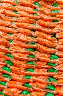 Stack of plastic bags packed with carrots