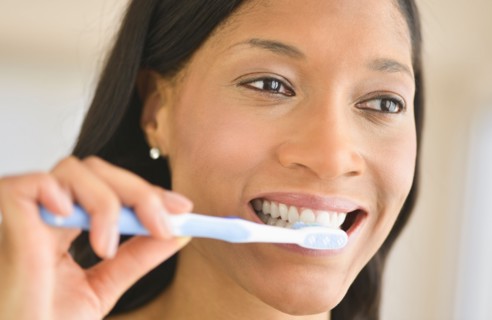 Woman brushing teeth.