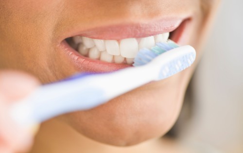 Close-up of woman brushing teeth.