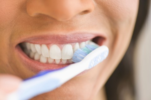 Close-up of woman brushing teeth.