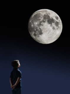 Boy (4-5) looking at full moon.